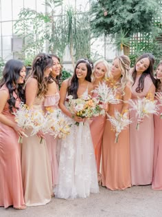 a group of women standing next to each other holding bouquets