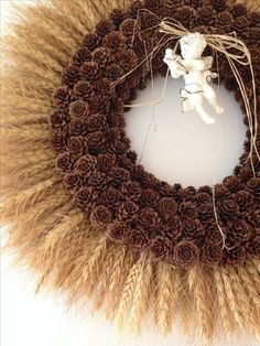 a wreath made out of pine cones with a angel on it