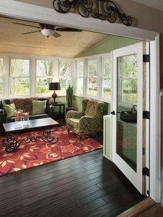 a living room filled with furniture and a fire place next to a doorway that leads to a covered patio