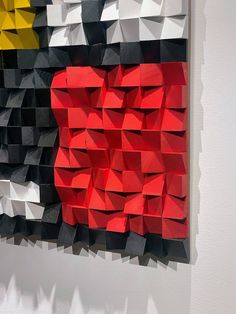 an abstract piece of art made out of folded origami pieces on a white wall