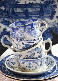 a stack of blue and white teacups sitting on top of eachother