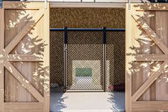 an open wooden gate in front of a building