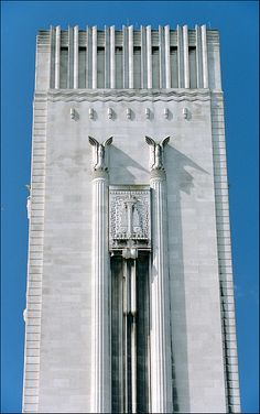 the top of a tall white building with two clocks on each of it's sides