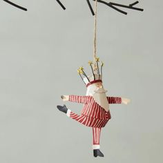 an ornament hanging from a tree with sticks sticking out of it's head