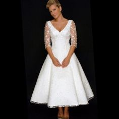 a woman in a white wedding dress posing for the camera with her hands on her hips