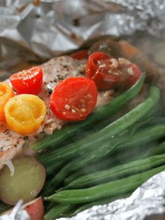 fish with tomatoes, onions and green beans on foil