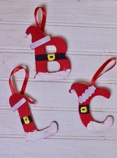 three christmas ornaments hanging on a white wooden surface