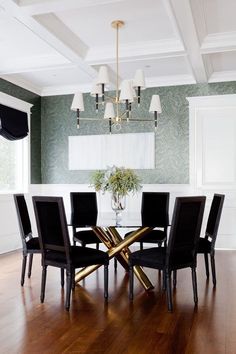 a dining room table with black chairs and a chandelier