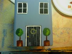 a cake with a house on it sitting next to a plate