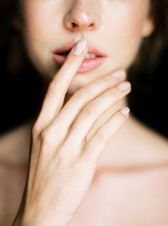 a close up of a woman with her hand on her chin and finger under her lip