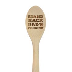 a wooden spoon with the words stand back and dad's cooking on it, in front of a white background