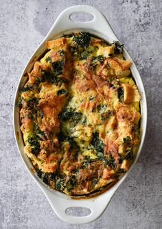 a casserole with spinach and cheese in a white dish on a gray surface