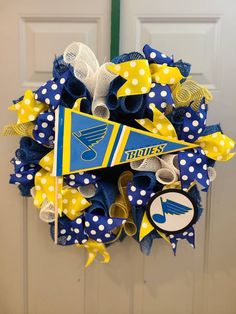 a blue and yellow wreath is hanging on the front door with white polka dot dots