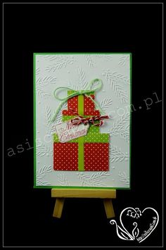 a christmas card on a easel with a green and red present box in the middle