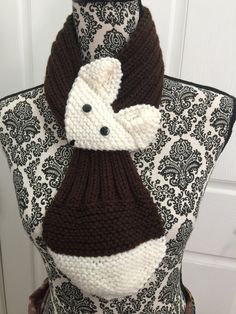 a knitted scarf on top of a mannequin's dummy wearing a brown and white sweater