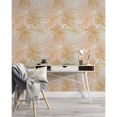 a room with a desk and chair in front of a wallpapered background that has palm leaves on it