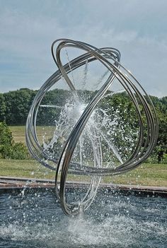 a large metal sculpture with water pouring out of it