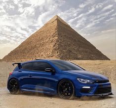 a blue car parked in front of a pyramid