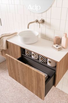 a bathroom with a sink, mirror and towel rack on the counter top in front of it