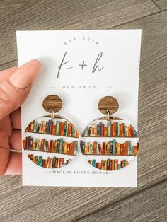 a pair of earrings with bookshelves on them