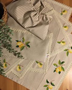 four pieces of cloth with lemons and leaves on them sitting on a wooden floor