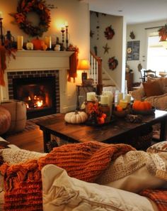 a living room filled with furniture and a fire place next to a fireplace covered in pumpkins