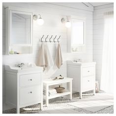 a white bathroom with two sinks and mirrors