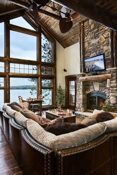 a living room filled with lots of furniture and a fire place in front of a large window