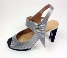 a women's shoe with silver leather and studded details