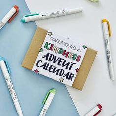 an assortment of markers, pens and notebooks on a blue background with the words kindness's adventure calendar