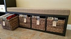 a bench with three baskets on it and some records in the bins next to it