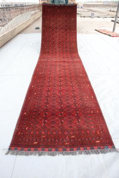 an old red rug is laying on the ground