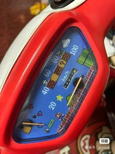 a close up of a red toy clock on a table