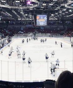 an ice hockey game is being played in a large arena