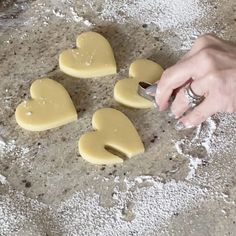 someone is cutting hearts out of dough on the counter with a pair of tongs