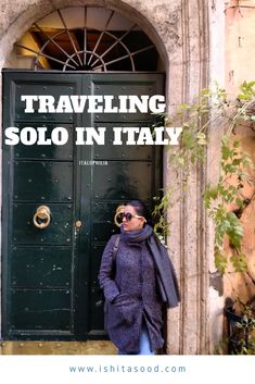 a woman standing in front of a green door with the words traveling solo in italy