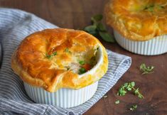 two pot pies sitting on top of a blue and white cloth next to each other