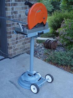 a machine that is sitting on top of a cement floor next to a brick building