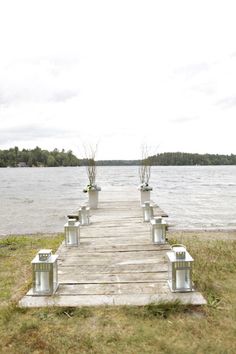 there are many planters on the end of a pier by the water's edge