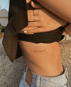 a woman with a small tattoo on her stomach