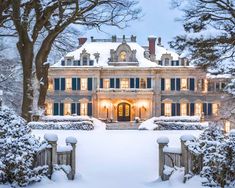 a large house covered in snow next to trees