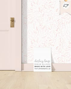 an open door with a sign in front of it on the floor next to a pink wall