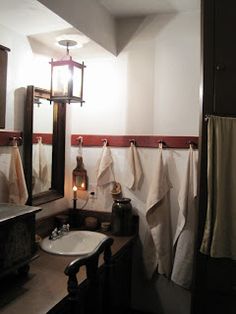 a bathroom with towels hanging on the wall next to a sink and mirror in it