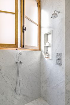 a bathroom with a window, shower head and marble counter top in front of it