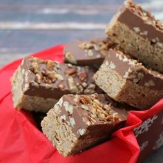 several pieces of chocolate peanut butter bars in a red paper bag