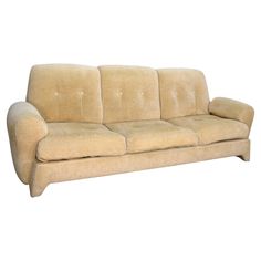 a beige couch sitting on top of a white floor