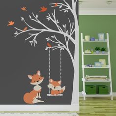 a room with a tree and two foxes on swing chains, painted in dark grey