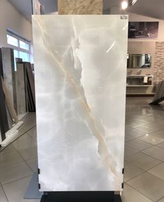 a large white marble slab in the middle of a tile flooring store display area