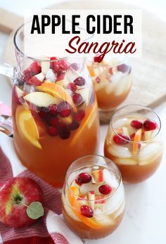 an apple cider sangria is garnished with cranberries and orange slices