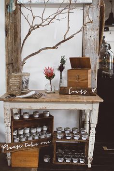 an old wooden table with jars and flowers on it